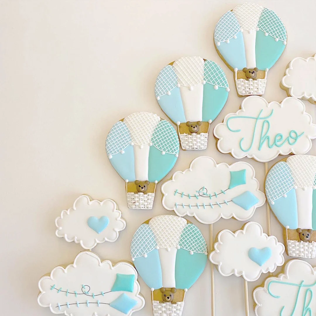 Biscoitos personalizados com balões azuis, nuvens e nome Theo